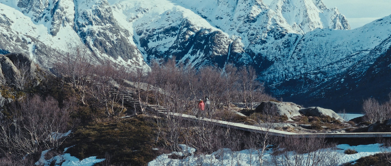 Two people walking through a mountain valley in the Lofoten Islands
